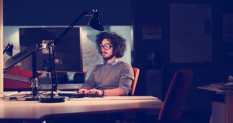 Image showing man working on computer in dark office