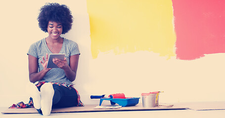 Image showing black female painter sitting on floor