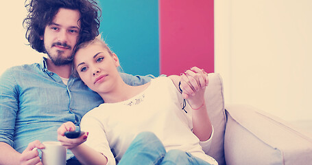 Image showing Young couple on the sofa watching television