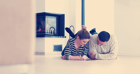 Image showing Young Couple using digital tablet on the floor