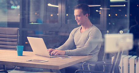 Image showing man working on laptop in dark office