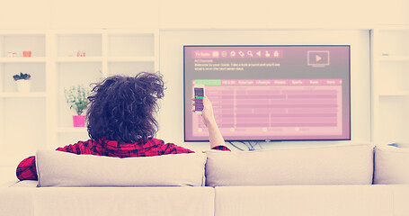 Image showing Young couple on the sofa watching television