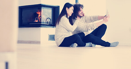 Image showing Young Couple using digital tablet on the floor