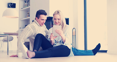 Image showing Young Couple using digital tablet on the floor