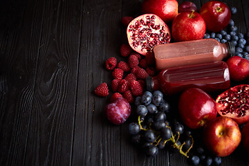 Image showing Mix of fresh red and black fruits. With botteled fresh juices