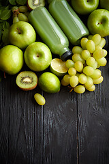 Image showing Mixed green fruits and vegetables placed on black wooden table