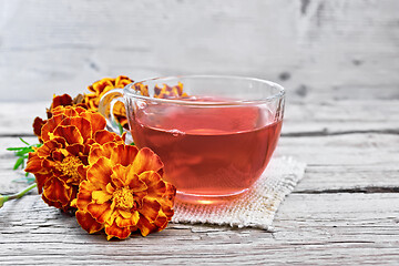 Image showing Tea herbal of marigolds in cup on burlap