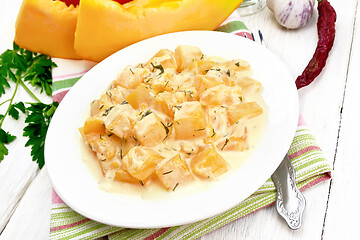 Image showing Pumpkin with sour cream sauce in plate on light wooden board