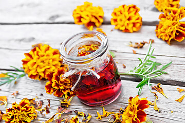 Image showing Alcohol tincture of marigolds in jar on board