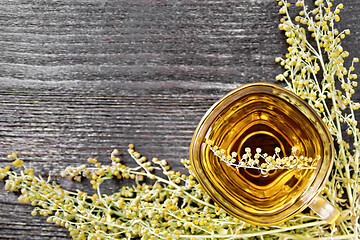 Image showing Tea of gray wormwood in glass cup on board top