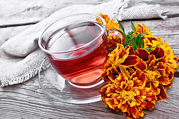 Image showing Tea herbal of marigolds in glass cup on gray board