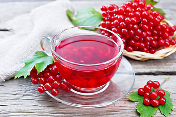 Image showing Tea from viburnum in cup with berries on old board