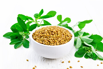 Image showing Fenugreek with green leaves in bowl on white board