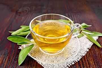 Image showing Tea herbal with sage in glass cup on dark wooden board