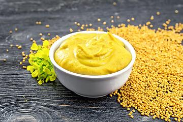 Image showing Sauce mustard in bowl with seeds and flower on black board