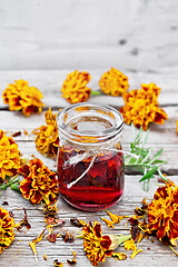 Image showing Alcohol tincture of marigolds in jar on old wooden board