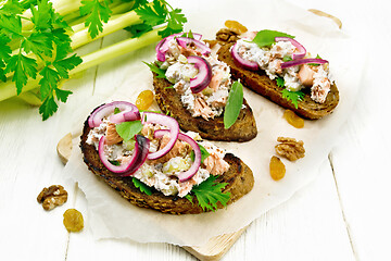 Image showing Bruschetta with fish and curd on wooden board