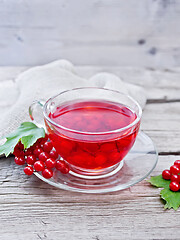 Image showing Tea from viburnum in cup with berries on old wooden board