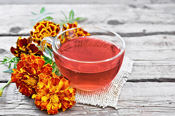 Image showing Tea herbal of marigolds in cup on napkin