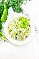 Image showing Salad of cabbage with cucumber in plate on light board top