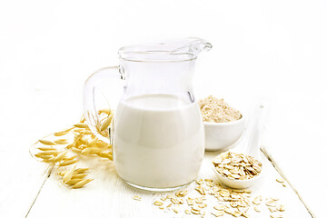 Image showing Milk oatmeal in jug on white wooden board