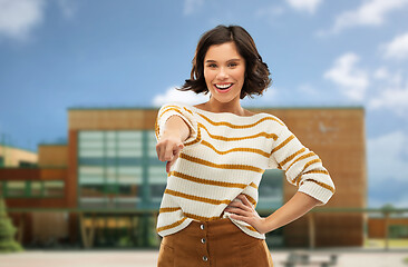 Image showing young woman pointing finger to you over school