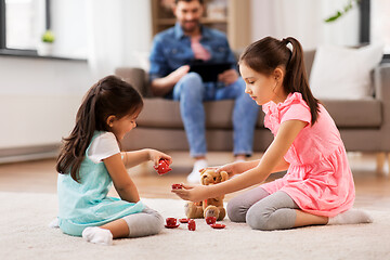 Image showing girls playing with toy crockery and teddy at home