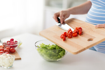 Image showing close up of pregnant woman cooking food at home