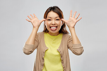 Image showing funny asian woman making silly faces