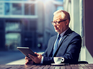 Image showing senior businessman with tablet pc drinking coffee