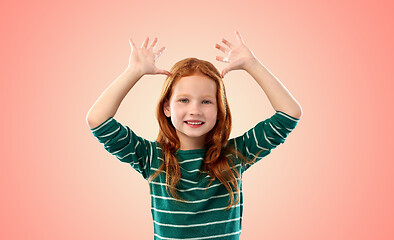 Image showing red haired girl having fun and making big ears