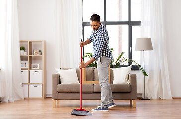 Image showing man with broom cleaning floor at home