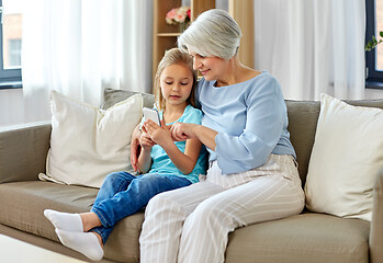 Image showing grandmother and granddaughter with smartphone