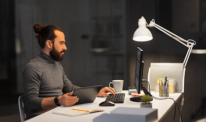 Image showing creative man with computer working at night office