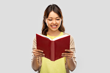 Image showing happy asian woman reading book