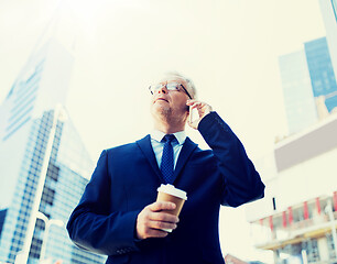 Image showing senior businessman calling on smartphone in city