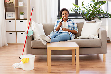 Image showing woman drinking coffee or tea after cleaning home