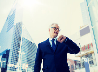 Image showing senior businessman checking time on his wristwatch