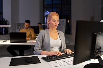 Image showing designer working on computer at night office