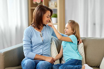 Image showing mother and daughter sitting on sofa at home