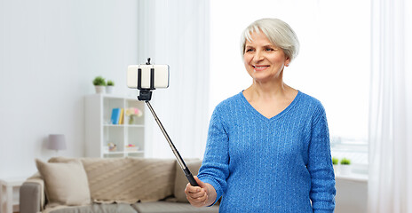 Image showing smiling senior woman taking selfie by smartphone