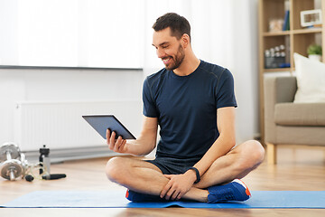 Image showing man with tablet computer on exercise mat at home