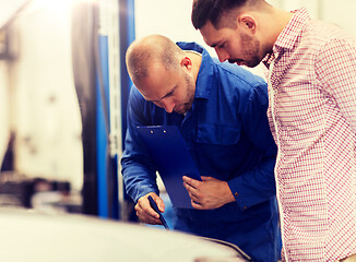 Image showing auto mechanic with clipboard and man at car shop