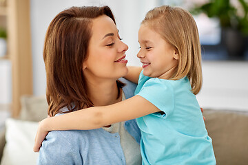 Image showing little daughter hugging her mother on sofa at home