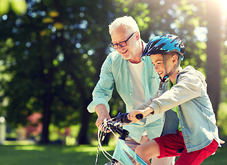 Image showing grandfather and boy with bicycle at summer park