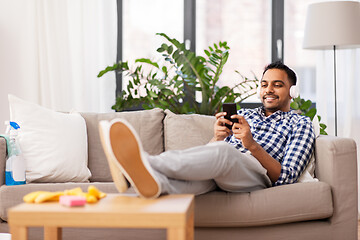 Image showing indian man in headphones after cleaning home