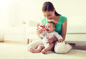 Image showing mother with spoon feeding little baby at home
