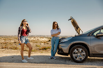 Image showing Girls with a broken a car on country road