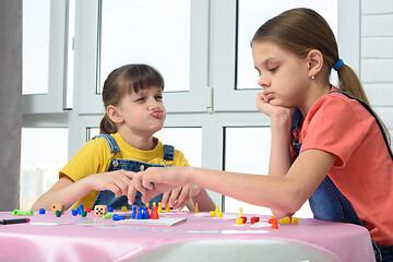 Image showing Girl playing a board game teases another girl