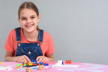 Image showing Girl sitting at the table playing board games, free space on the right